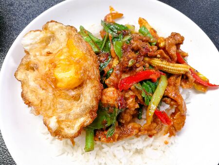 stir fried pork with red curry paste and sweet basil on jasmine rice streamの写真素材