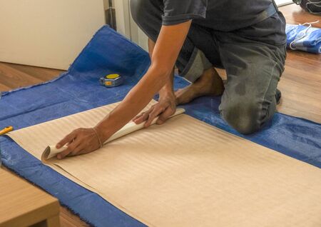 worker male prepare wallpaper for install at wall in new room.の写真素材