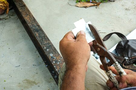 worker man use hand make cross aluminium by use scissorsの写真素材
