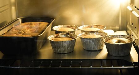 bakery shop baking cake in hot ovenの写真素材