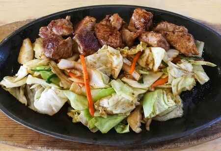 Teriyaki pork steak slice dice with vegetable salad in metal panの写真素材