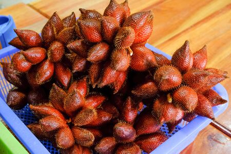 group of freshness red salak or salacca zalacca fruit in basket for sell in traditional market. sweet and sour tasty and fragrance.の写真素材