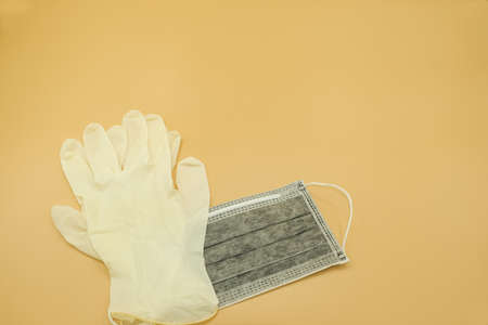 single charcoal carbon paper mask surgical and latex gloves filter dust pollution and disease virus. safety medical equipment. Isolated on yellow background.の写真素材