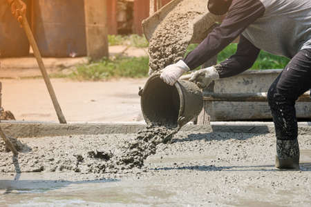 masonry labor building house use bucket mix and fill liquid cement on floor. Making concrete street...