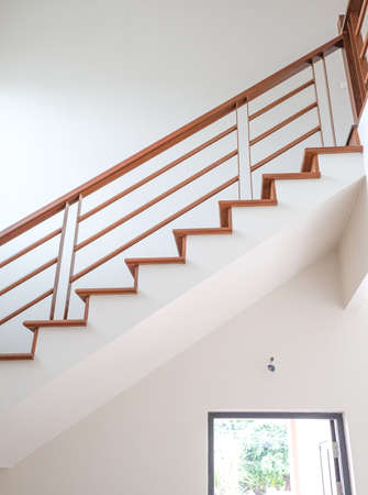 abstract start to goal up to stair. wooden in new house structure use lightweight cement brick and white lintel plaster to joint for reinforce in site. oak color iron Handrail decor interior estate.の写真素材