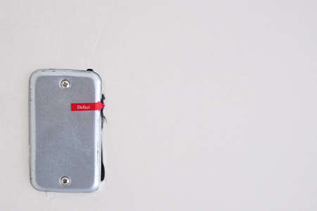 red sign tag for check defect cement construction new house. iron eletric block in white concrete wall.の写真素材