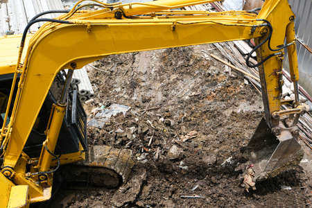 yellow excavator hydraulic engine or macro truck working in house construction site separate garbage...