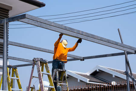 builder worker use measure tape iron heavy metal prepare for install garage roofの写真素材