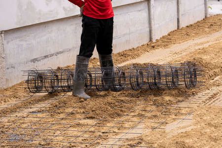 worker stand install wire mesh on sand floor for reinforce concrete before fill liquid cement on...