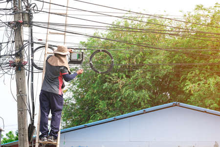 service man climbing high bamboo stair wooden for service maintenance upgrade speed fiber optic line.  technician professional male connect telecom network .の写真素材