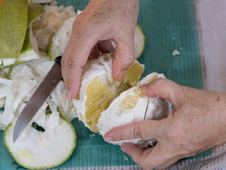 golden women peel pomelo sweet organic tropical fruit holding on body hand. fresh big yellow orange citrus spit for share.の写真素材
