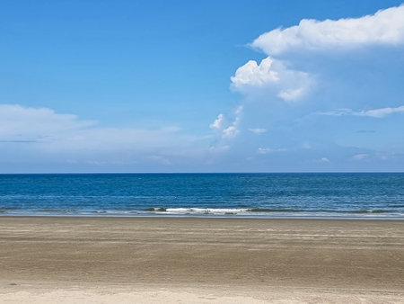 beautiful golden sand beach sunrise fresh sea breeze summer vacation. blue sky and white clouds.