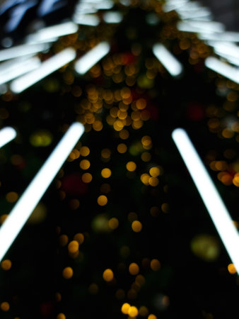 abstract bokeh blur light orange and white long glowing flare pattern christmas tree black backgroundの写真素材
