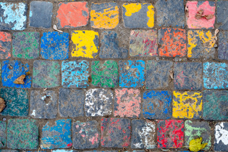Photo of a vibrant street art piece featuring painted cobblestones in an array of colors, offering a playful twist on urban surfaces.の写真素材