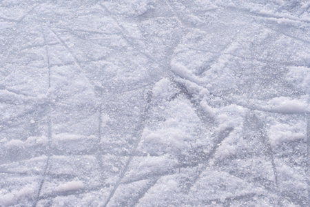 A detailed photo of an ice skating rinks scratched surface texture, showcasing the numerous skate scratches formed during winter activities.の写真素材