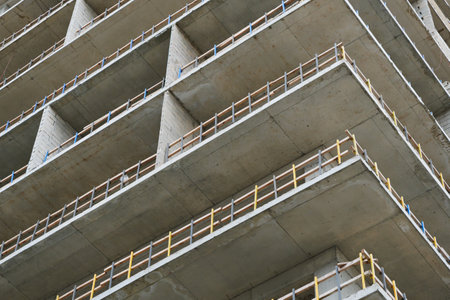 View of a concrete building with multiple floors, showcasing the construction progress and safety...