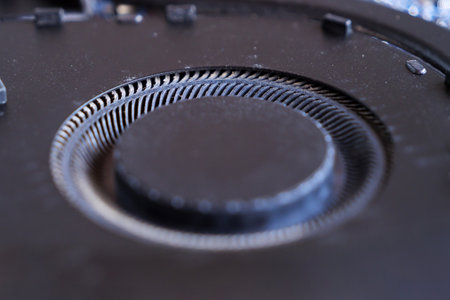 A closeup view of a black laptop cooler fan with noticeable dust buildup on the blades, indicating potential maintenance needs for improved performance.の写真素材