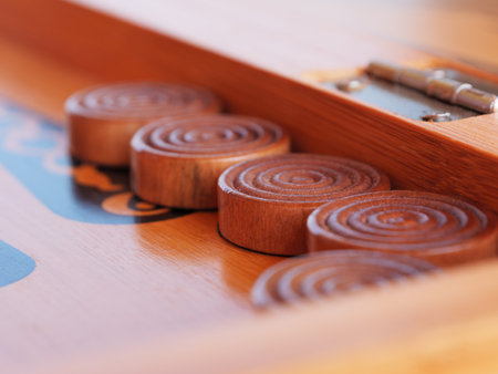 Wooden game pieces arranged neatly on a traditional backgammon game board.