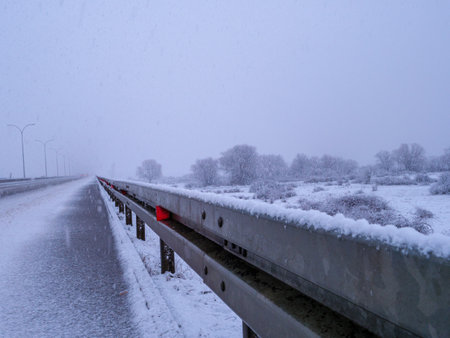 A snowy highway glistens under falling snow, a winter wonderland.の写真素材