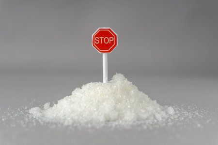 A symbolic photo showing a red stop sign embedded in white sugar on a spoonの写真素材
