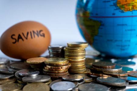 Global finance, investment, and savings concept. Stacked coins, world globe, and egg with 'SAVING' text. Economic future planning.の写真素材
