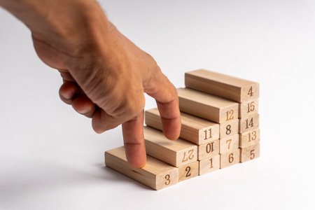 Hand mimics walking up numbered wooden blocks arranged as stairs, symbolizing progress, growth, development, success, and goal achievement in life or business.の写真素材