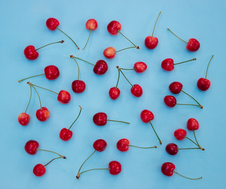 Red cherries on a blue background - summer background
