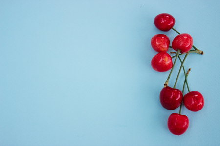 Blue background with red cherries, summer backgroundの写真素材