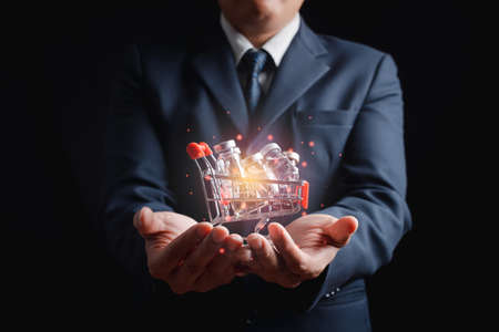 Businessman holds a medical vaccine against  The concept of doing business, trade, vaccines, and taking care of health is made safe by vaccinationの写真素材
