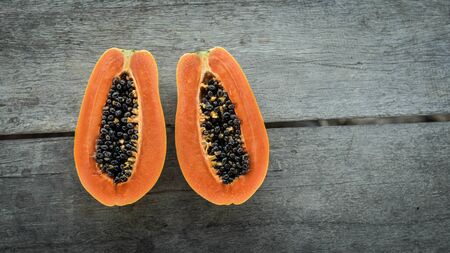 Half cut papaya placed on a wooden background.Papaya fruit on wooden background.close up papaya image.の写真素材