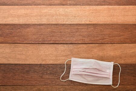 Pink face mask on wooden table texture backgroundの写真素材