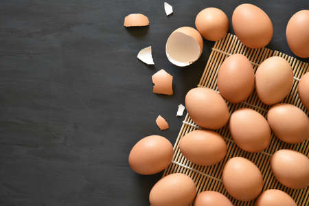 Eggs arranged in a black wooden background.の写真素材