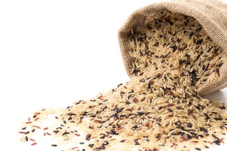 brown rice grains isolated on white backgroundの写真素材