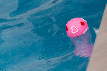 pink heart ball in poolの写真素材