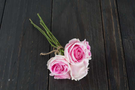 white and pink roses bouquet on wood backgroundの写真素材