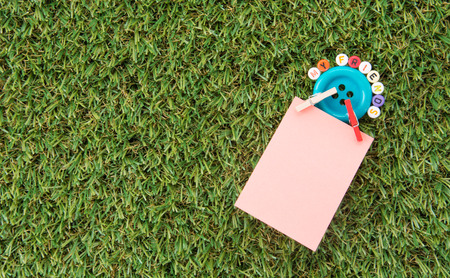 Notepaper on green grass backgroundの写真素材