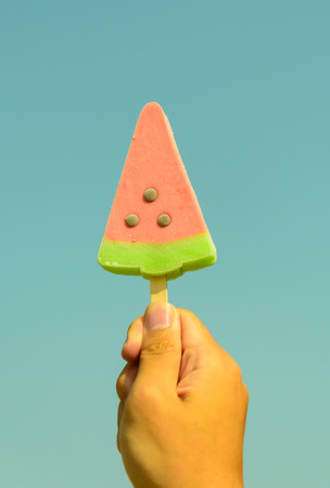 watermelon ice-cream on hand in blue sky in retro and vintage toneの写真素材