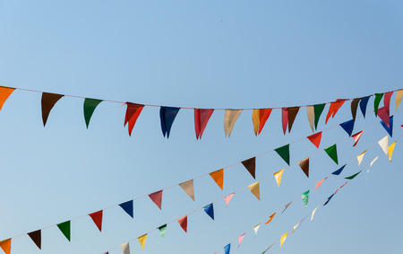 colorful festive bunting flags against a blue sky background