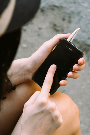 Woman hands touching smartphone in vintage style and film textureの写真素材