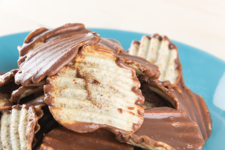 potato chip with chocolate on woodの写真素材