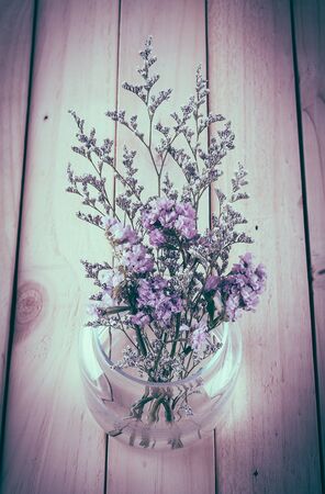 statice flower bouquet  on wood background - soft focus with vintage film filterの写真素材