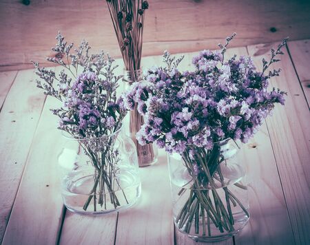 statice flower bouquet  on wood background - soft focus with vintage film filter