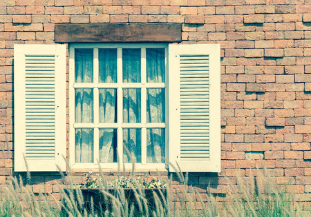 white vintage window on brick wall - soft focus with vintage filterの写真素材