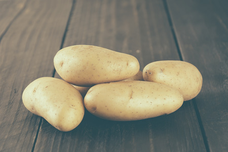 potatoes on wood background - soft focus with vintage film filterの写真素材