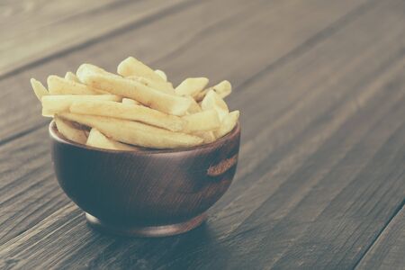 french fries on wood background - soft focus with vintage film filterの写真素材