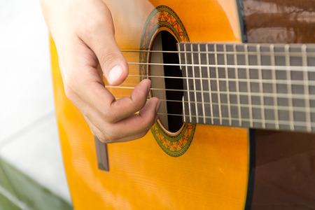 hand playing on acoustic guitar - soft focus with vintage filter