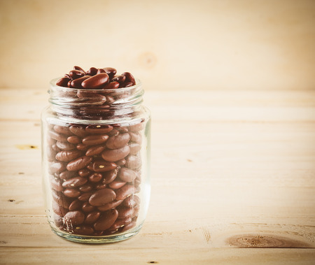 red  beans on wood background - soft focus with vintage film filterの写真素材