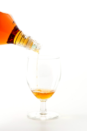 pouring wisky on white backgroundの写真素材