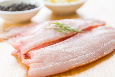 tilapia raw on wood boardの写真素材