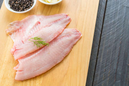 tilapia raw on wood boardの写真素材
